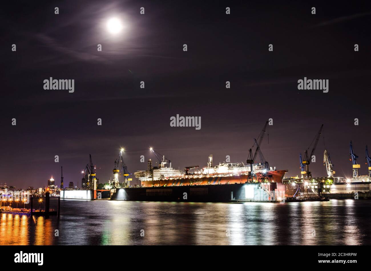 Night shot of dock with large container vessel on the Elbe river in Hamburg, Germany Stock Photo