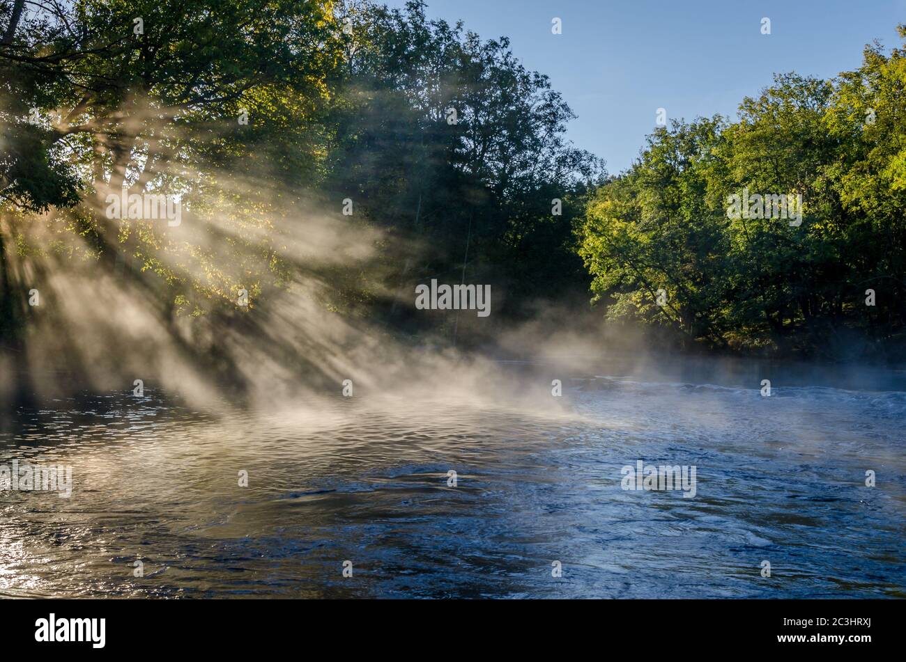 View of a beautiful landscape, with trees, water, morning light and mist. Stock Photo