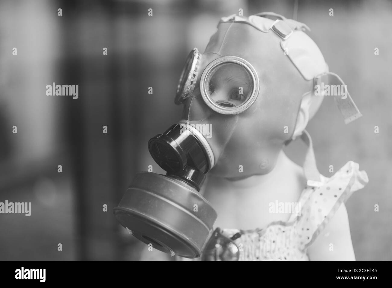 Greyscale shot of a child wearing a full face respirator mask - Pandemic Stock Photo