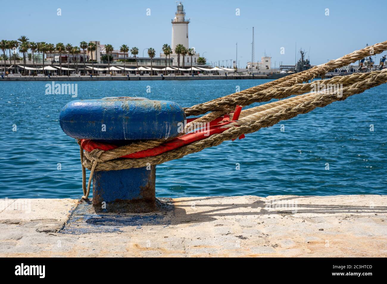 Mooring lines. Ropes secured in a blue mooring bollard on an empty dock