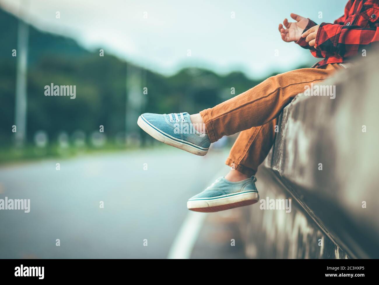 a boy sitting alone  with her feet pointing down in vintage tone Stock Photo