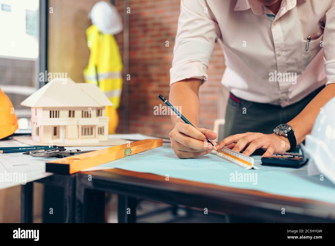 engineers holding a pen pointing to a building and drawing outlay