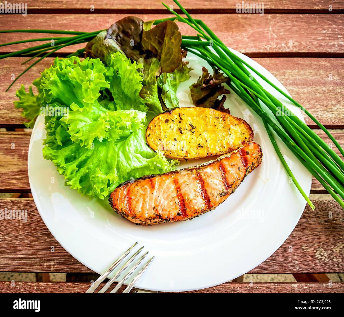 Grilled salmon fillet with potato and salad, top view Stock Photo
