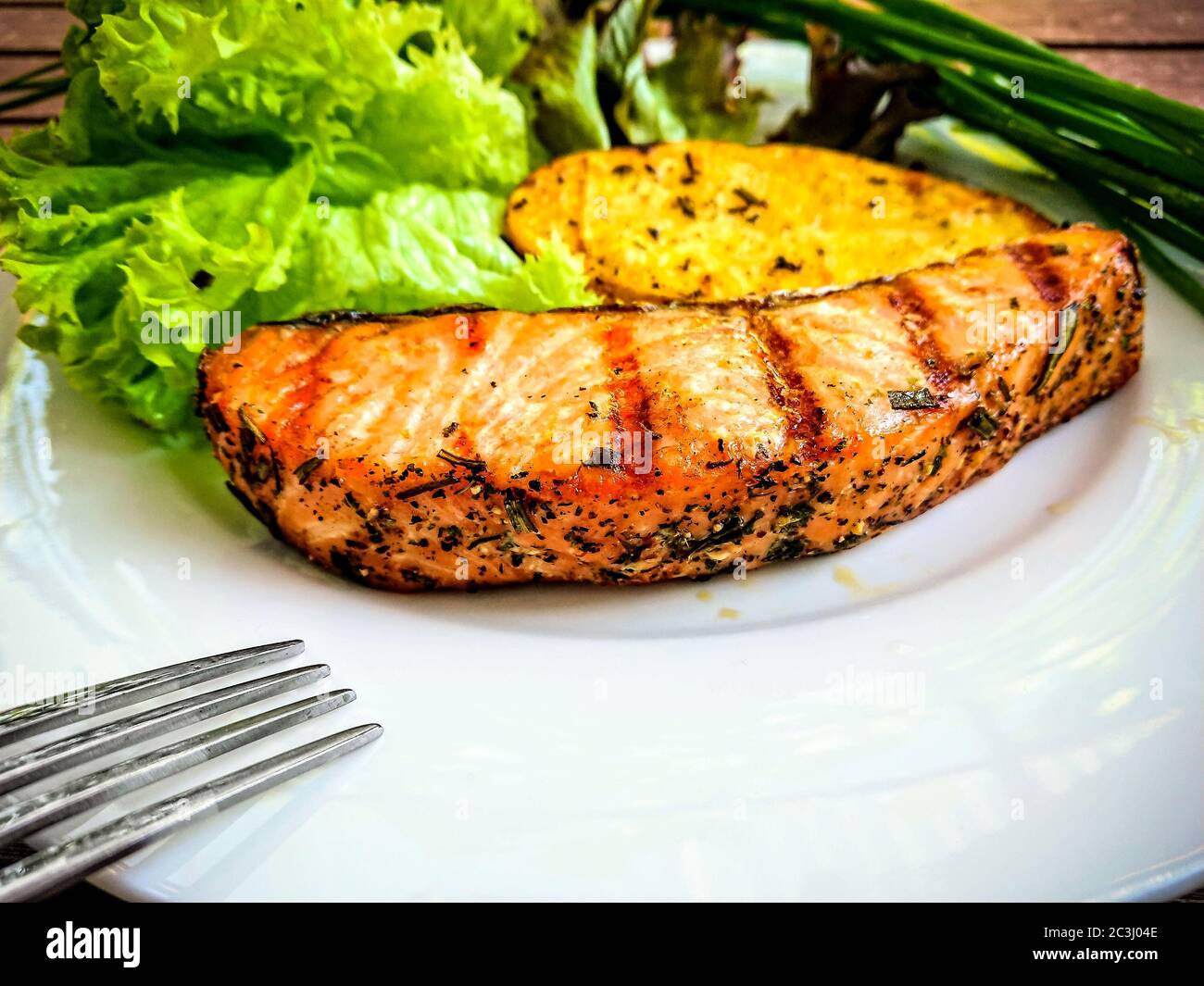 Grilled salmon fillet with potato and salad, top view Stock Photo