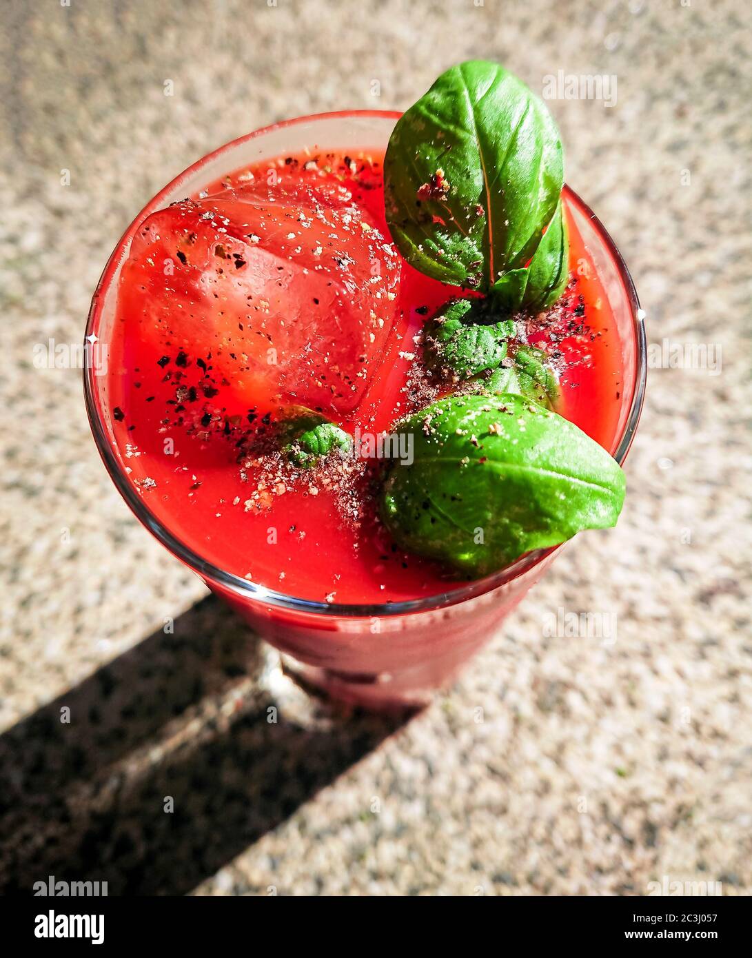 Tomato juice with ice and basil outside, top view Stock Photo