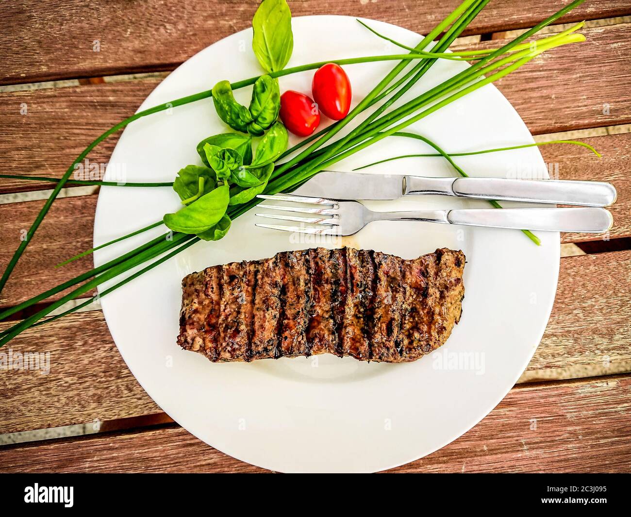 Grilled lamb fillet pieces on a plate with green, top view Stock Photo