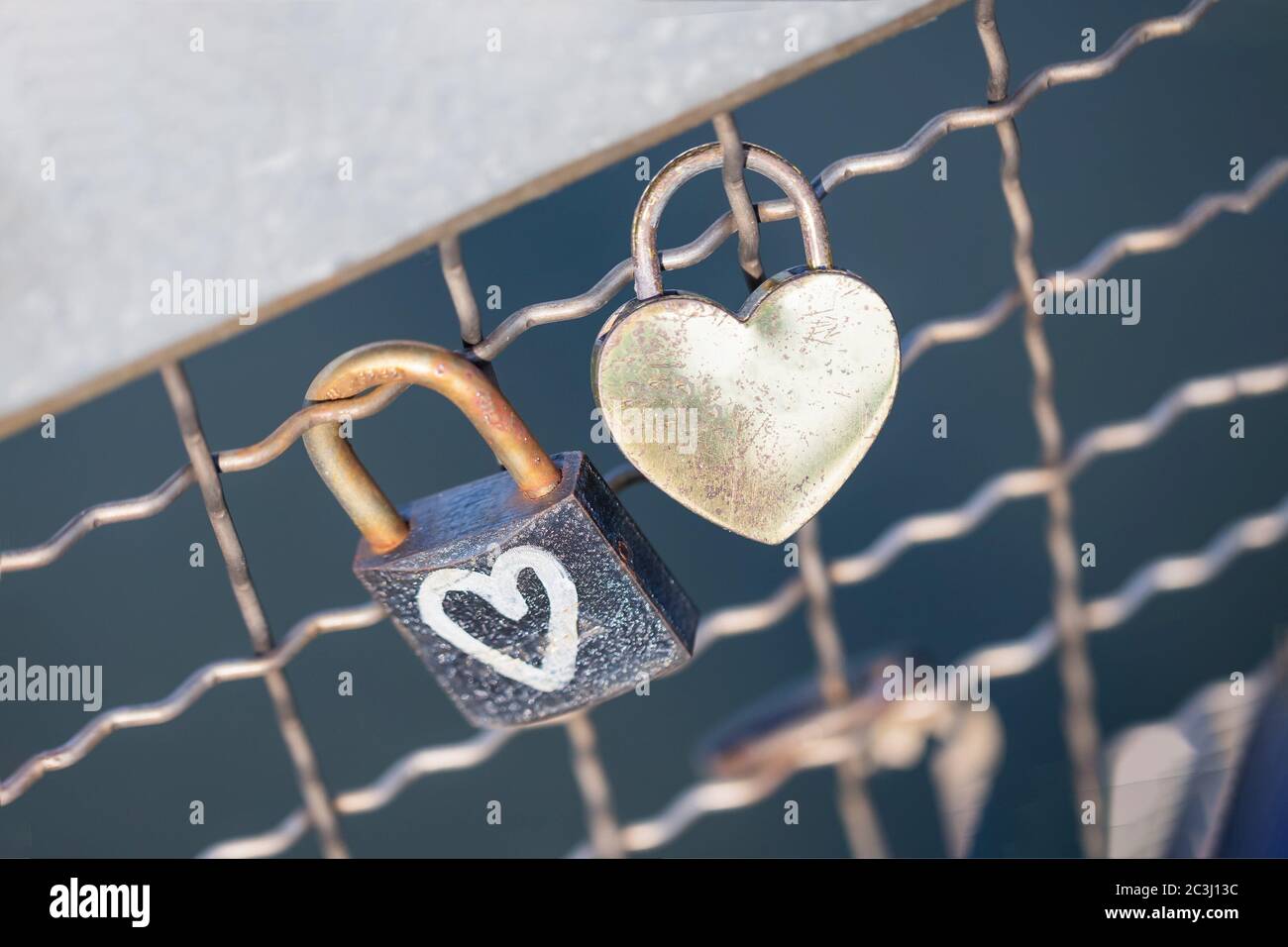 Two old rusty padlocks with heart on the bridge Stock Photo