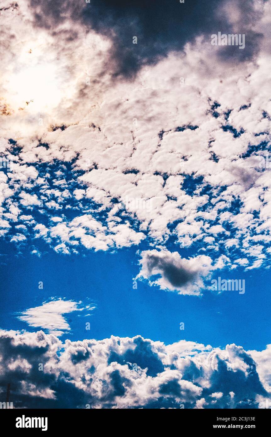 Vertical low angle shot of the beautiful fluffy clouds in the blue sky ...