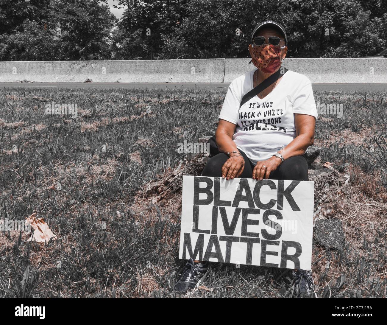 Juneteenth Protest Black Lives Matter George Floyd March - Solo black female woman holding black lives matter sign with grey background Stock Photo