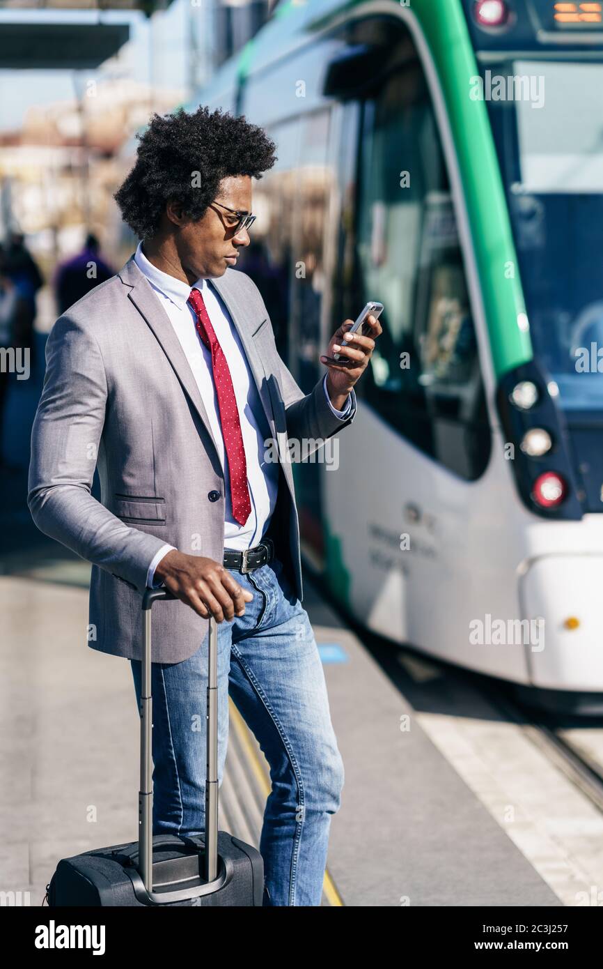 Black Businessman wearing suit waiting his train Stock Photo Alamy