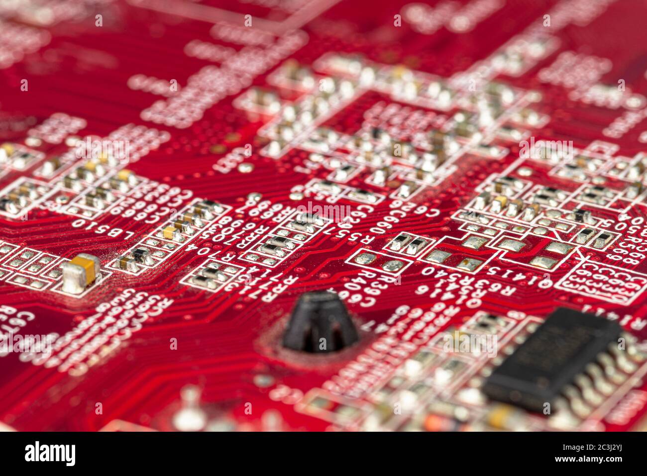 Macro photo of electrical paths on red circuit board, visible resistors