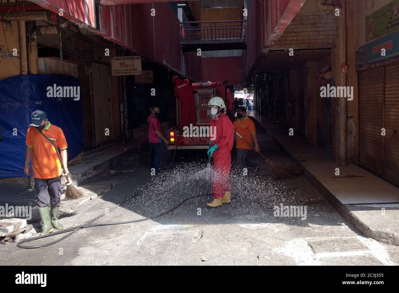 Officers spray disinfectant to curb the spread of coronavirus at the market.Government has re-closed the Kebayoran Lama market after 14 traders were declared positive with Covid-19 after following a medical swab test a few days ago. Stock Photo