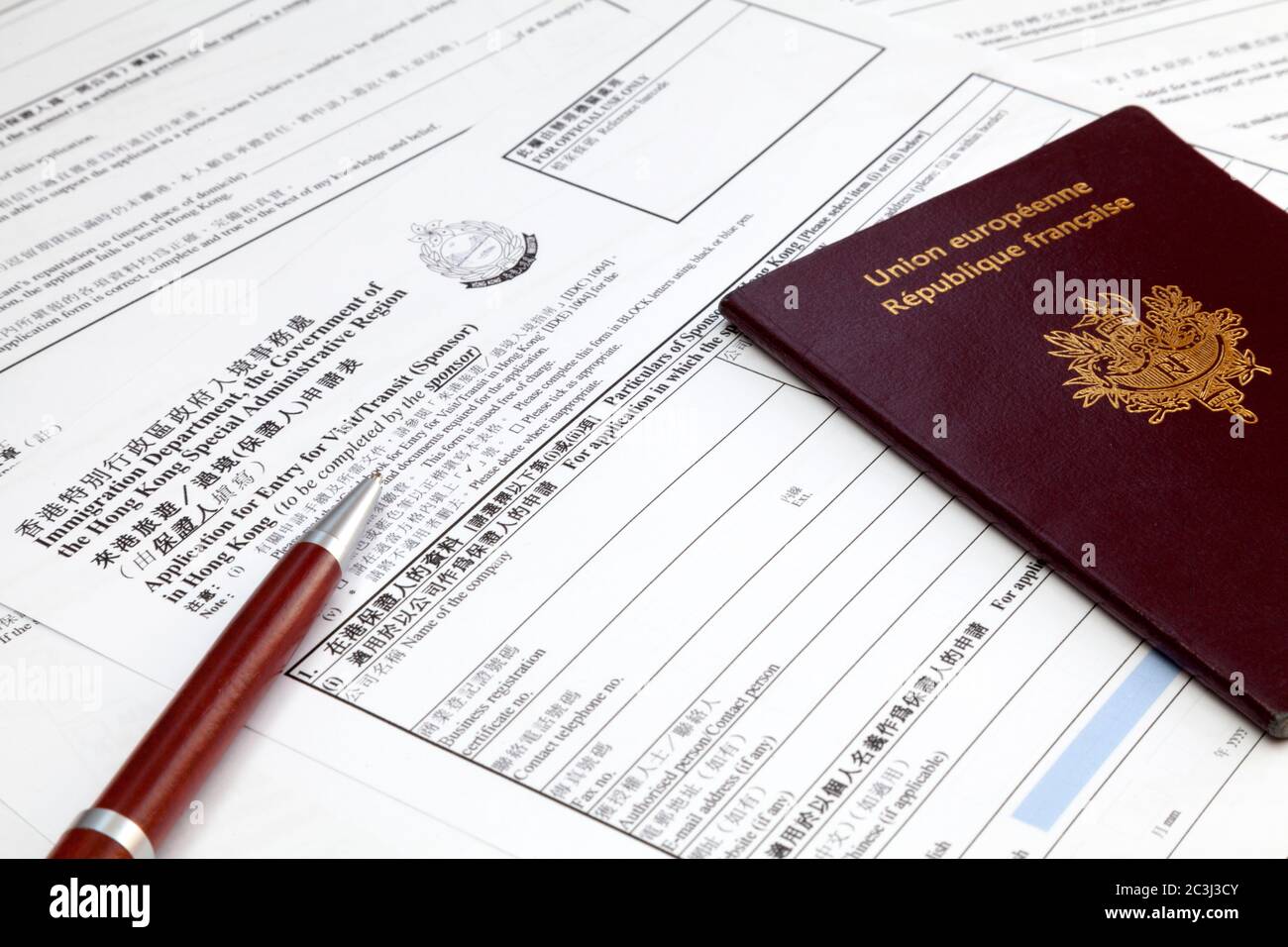 A ballpoint pen and a french passport on the top of a visa application form  for Hong Kong Stock Photo - Alamy