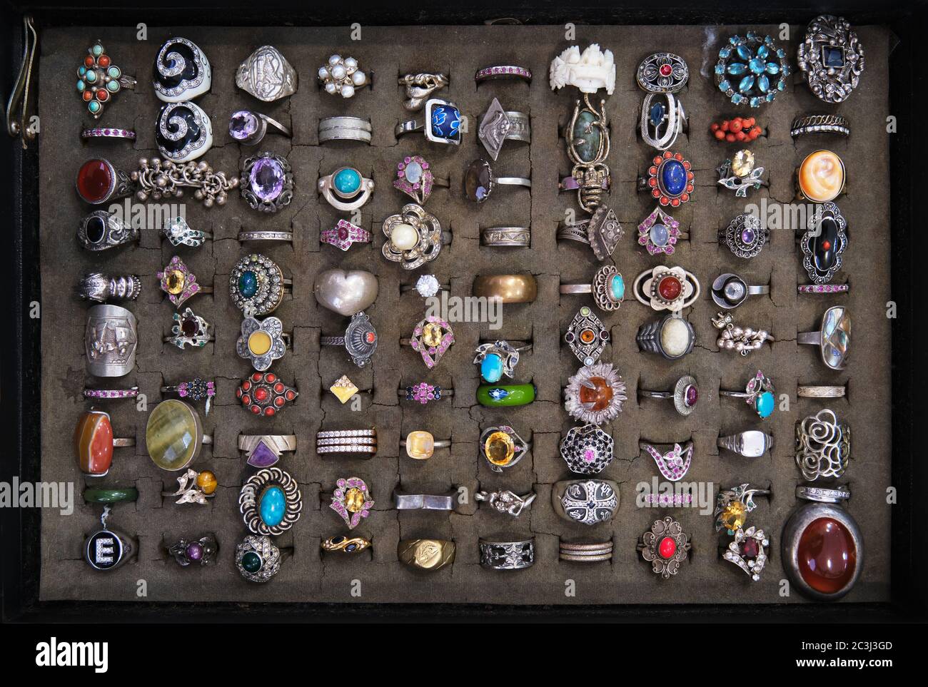 Assorted colorful vintage rings on a flea market stall sale in Italy, various designs and materials including precious stones, diamonds, silver Stock Photo