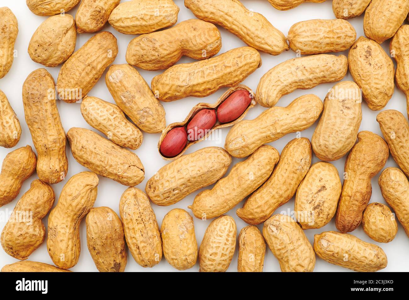 Peanuts background with one opened peanut nutshell containing three