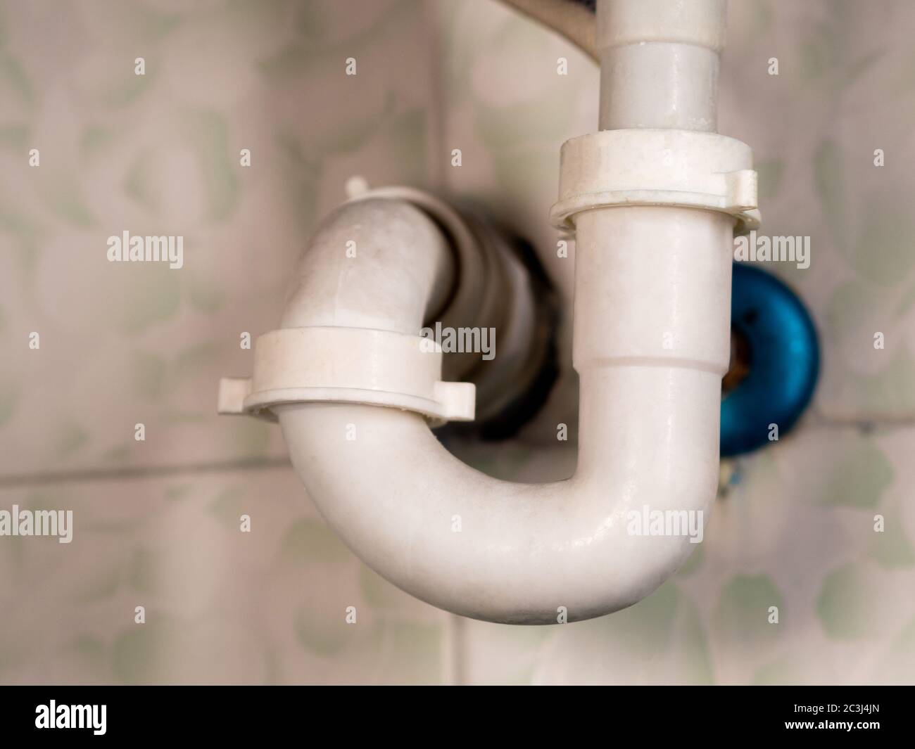 white bathroom drain pipe pipes and ceramic wall close-up Stock Photo