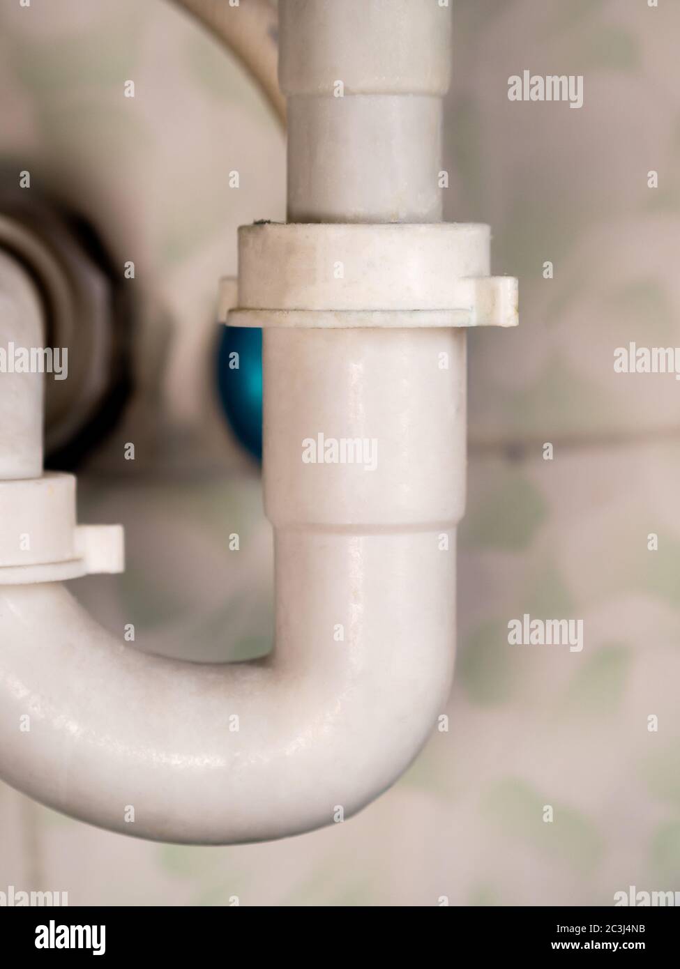 white bathroom drain pipe pipes and ceramic wall close-up Stock Photo