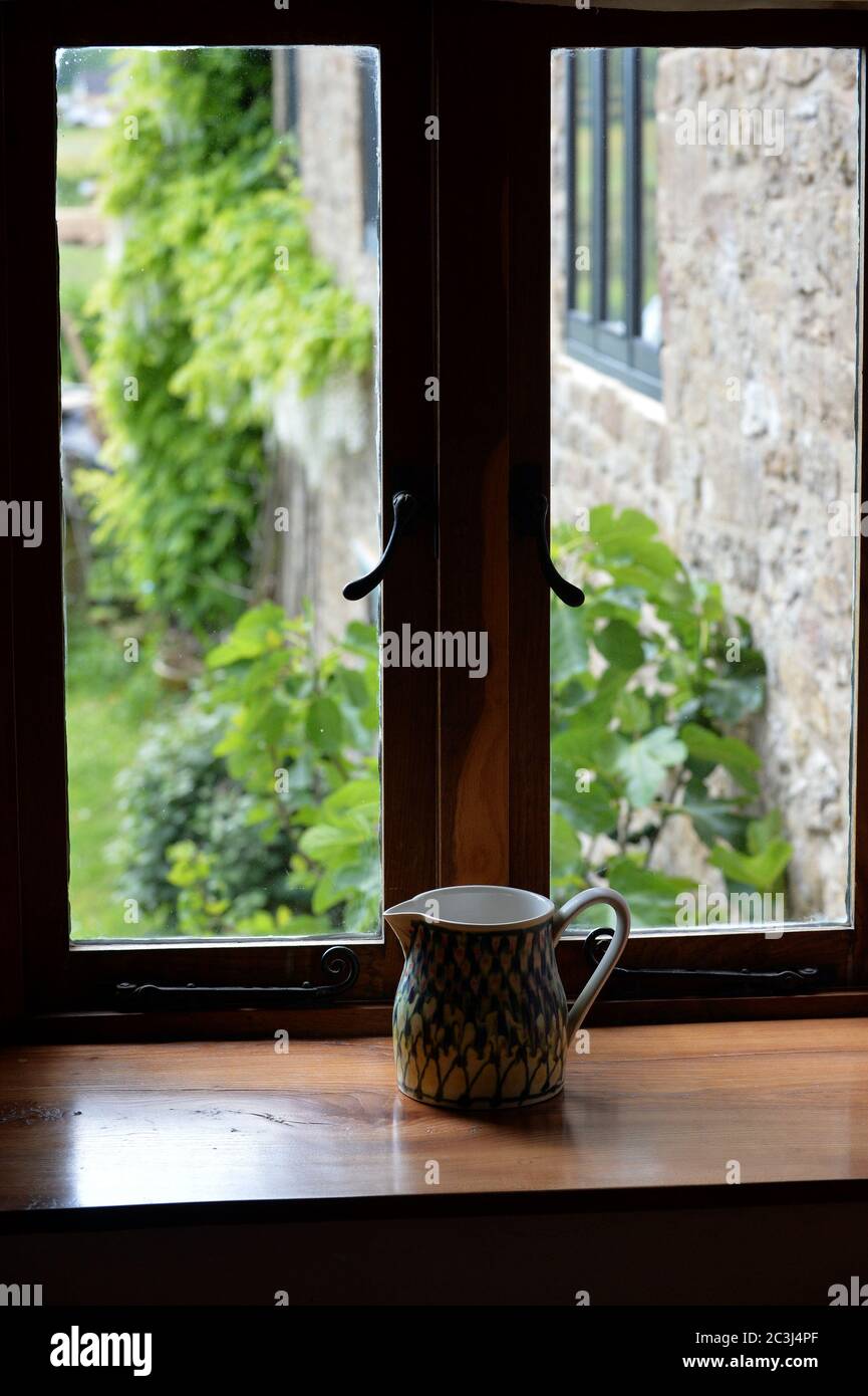 designer fine china jug on wooden Elm windowsill Stock Photo
