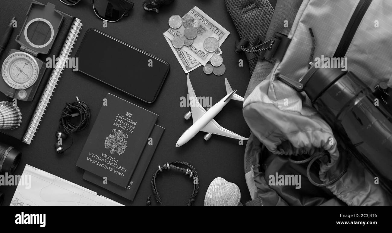Travel and Tourist concept. Vacation and travel accessories placed on black background. With map, camera, passport, money, backpack, smartphone. Flat Stock Photo