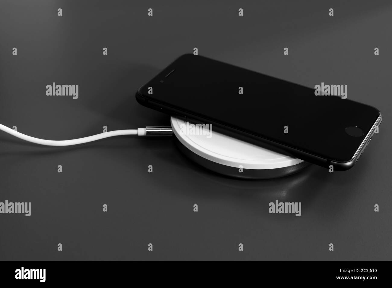Close-up mobile phone charging on a wireless charging device Stock Photo