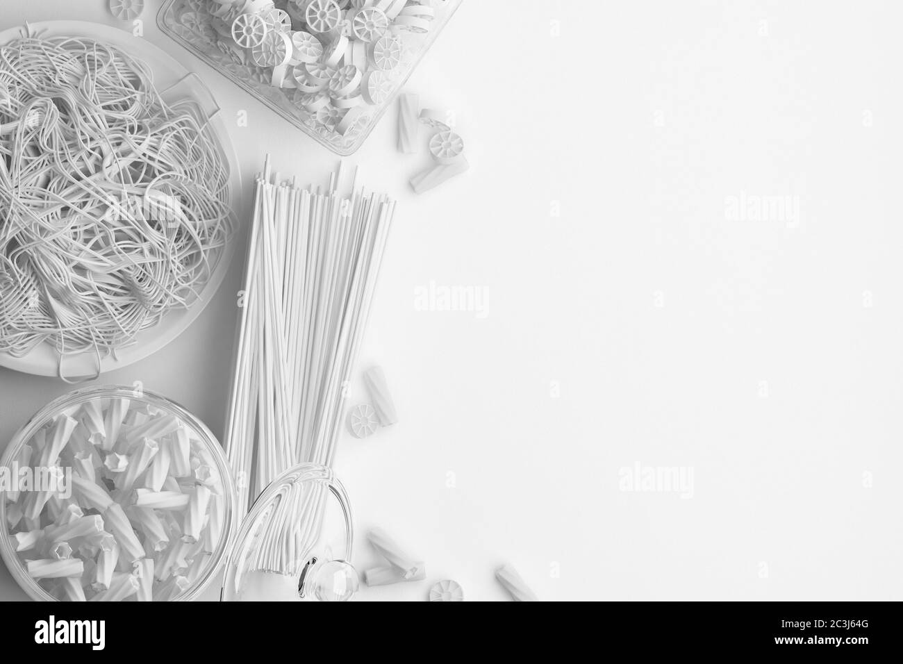 Monochrome composition of dry and boiled pasta and spaghetti on a white background. Banner with copy space for text. A set of food on the top view. 3D Stock Photo