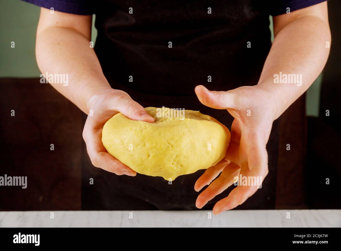 A woman holds dough for baking tasty sweet pie. Stock Photo