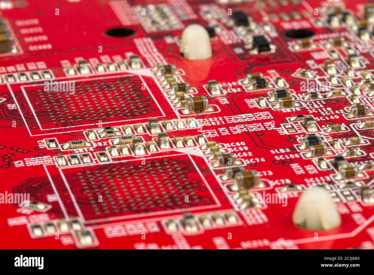 Macro photo of electrical paths on red circuit board, visible resistors