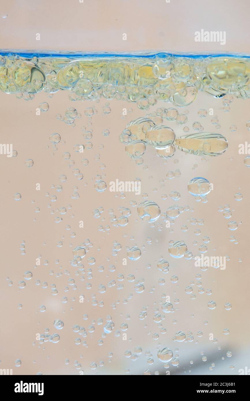 Oil bubbles in water with beige background. Stock Photo