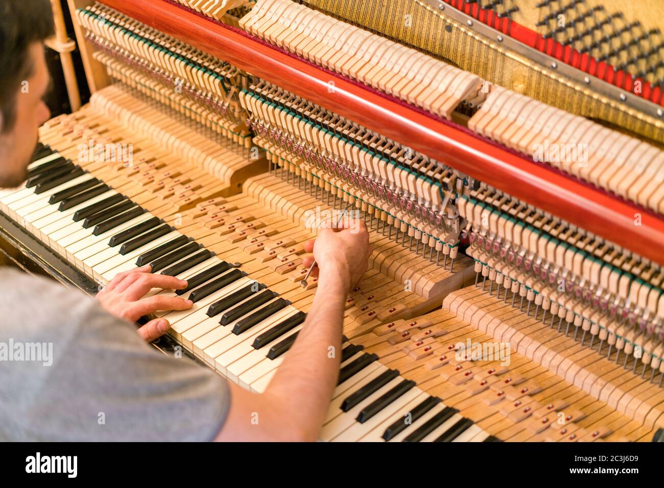 Piano tuning process. closeup of hand and tools of tuner working on grand  piano. Detailed view of Upright Piano during a tuning Stock Photo - Alamy