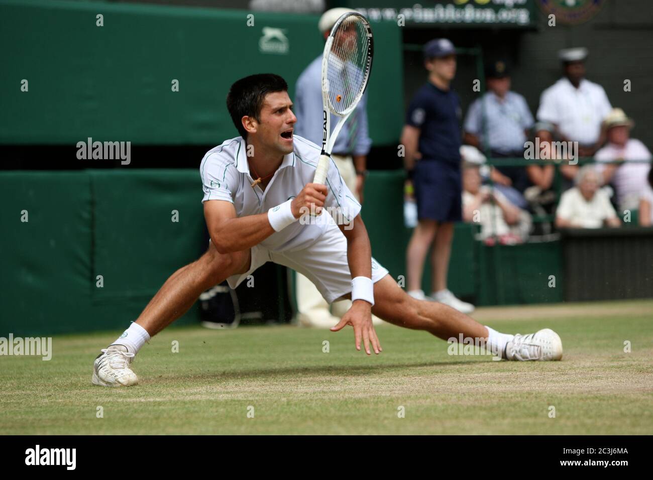 Novak Djokovic reaches wide for a forehand during his his semi-final match against Tomas Berdych at Wimbledon. Stock Photo