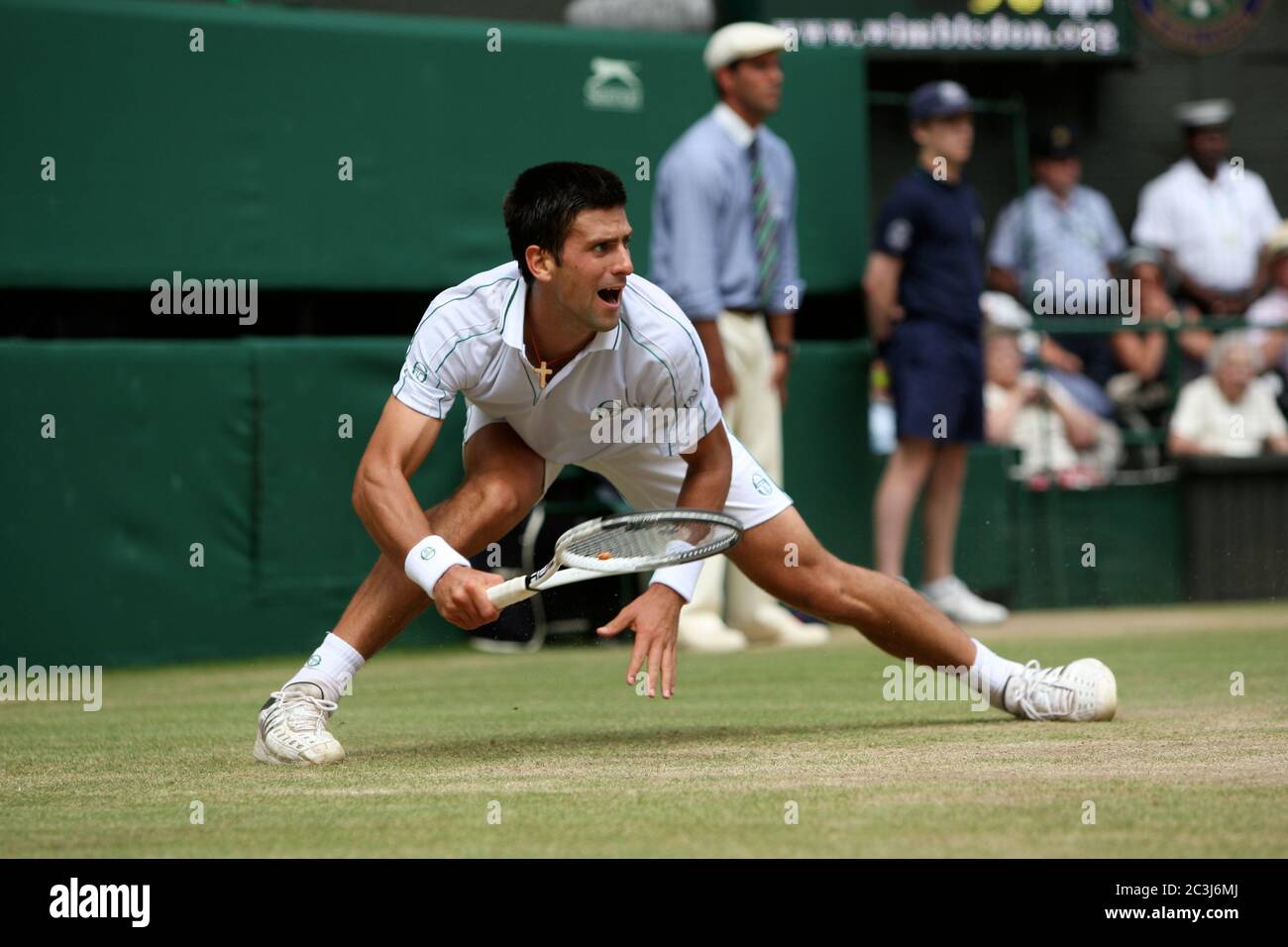 Novak Djokovic reaches wide for a forehand during his his semi-final match against Tomas Berdych at Wimbledon. Stock Photo