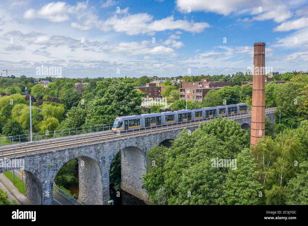 Luas Green Line tram crossing the viaduct Nine Arches Bridge over the River Dodder in Milltown, Dublin. Stock Photo