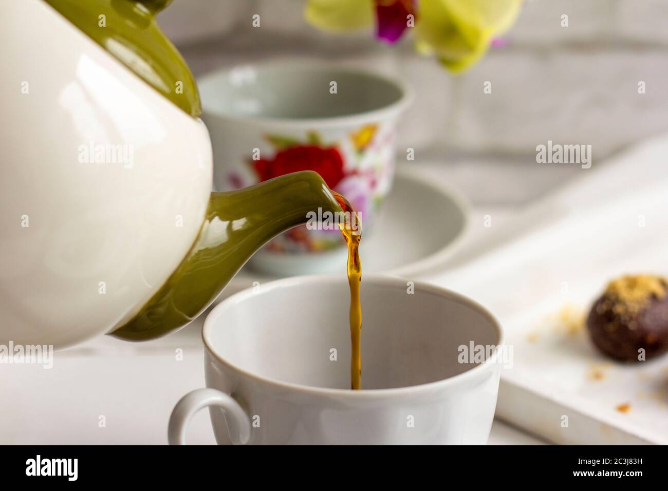 Pouring hot water into a white mug from the kettle- Making a cup of tea in  the kitchen Stock Photo - Alamy