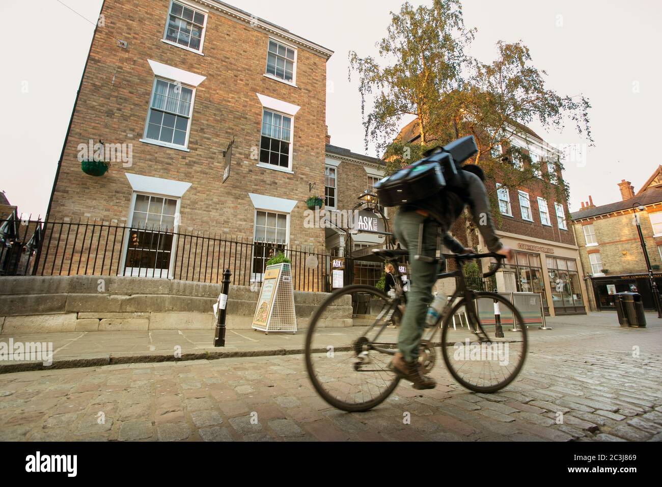 A cyclist riding past The Ask Italian restaurant Kings Bridge High