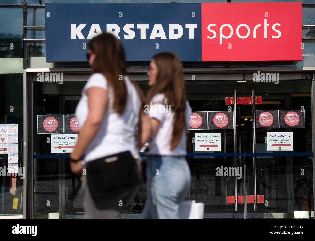 Dortmund, Germany. 20th June, 2020. Two passers-by walk past a Karstadt Sports branch. In addition to the planned closure of dozens of branches of the department store chain Galeria Karstadt Kaufhof, 20 of the 30 branches of the Karstadt Sports subsidiary are also to close. Credit: Bernd Thissen/dpa/Alamy Live News Stock Photo