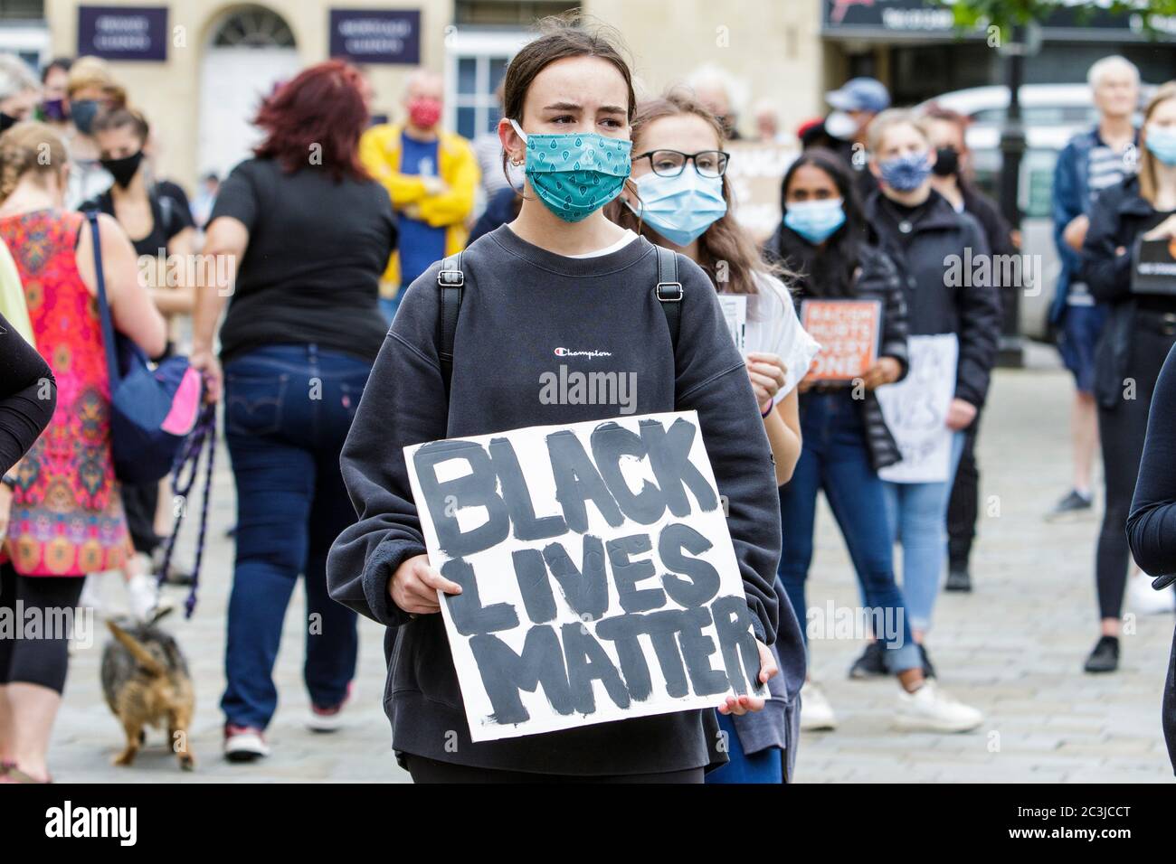 Chippenham, Wiltshire, UK. 20th June, 2020. BLM Protesters abiding by social distancing rules are pictured taking part in a ‘black lives matter’ BLM protest in the town's Market Place. The rally was organised in order for local people to draw attention to racism in the UK and to show solidarity with other BLM protests that have been taking place around the world after the death of George Floyd who died in police custody on 25th May in Minneapolis. Credit: Lynchpics/Alamy Live News Stock Photo