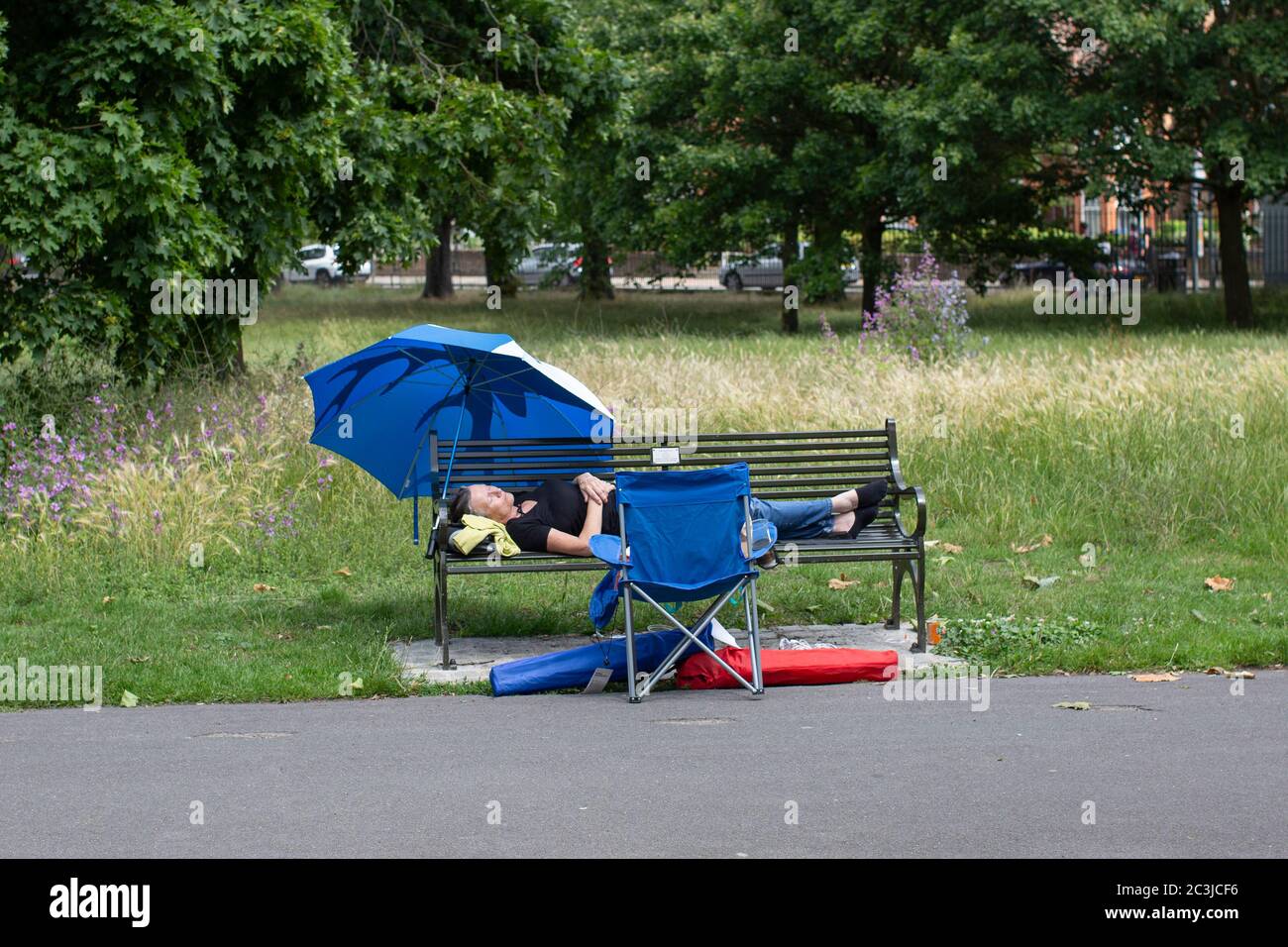 Woman asleep on park bench hi-res stock photography and images - Alamy