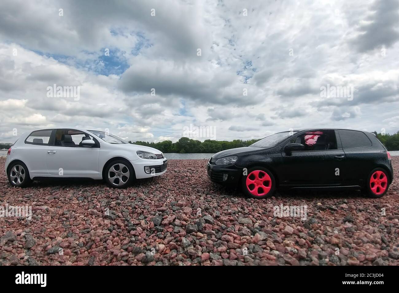 Moscow, Russia - May 03, 2019: Two toy cars Volkswagen golf mk6 stand on a pebble beach of Moscow river. White and black GTI stand opposite each other Stock Photo