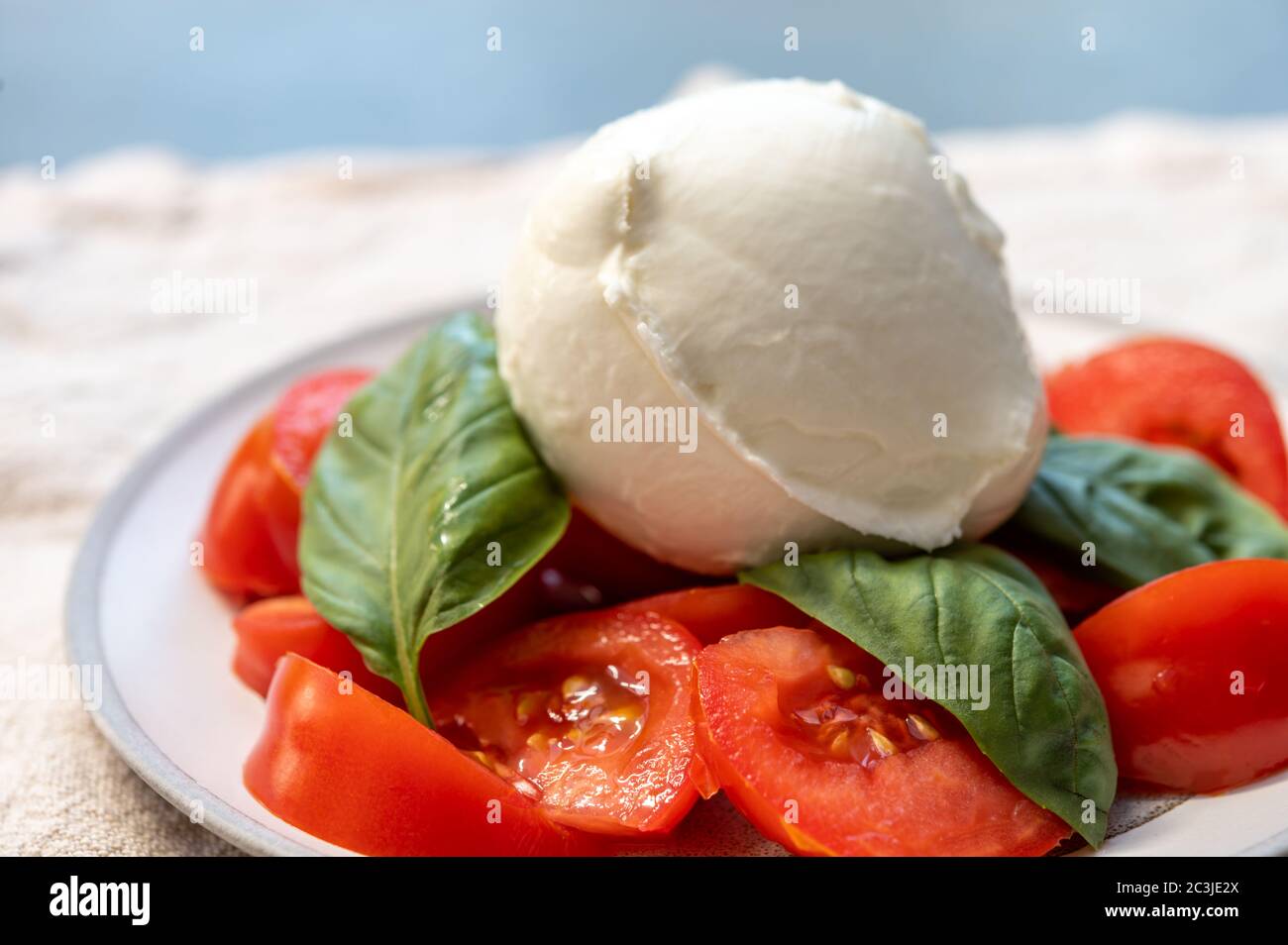 Ingredients for vegetarian caprese salad, ball of buffalo mozzarella  cheese, fresh basil, tomatoes. Italian food served outdoor on terrace,  close up Stock Photo - Alamy