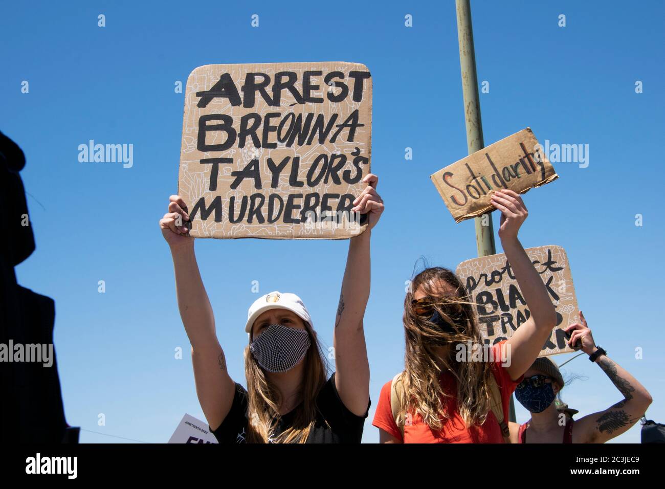 A protester carries a sign that says, 'Arrest Breonna Tayloer's murderers' at a Black Lives Matter march at the Port of Oakland on June 19, 2020. Stock Photo
