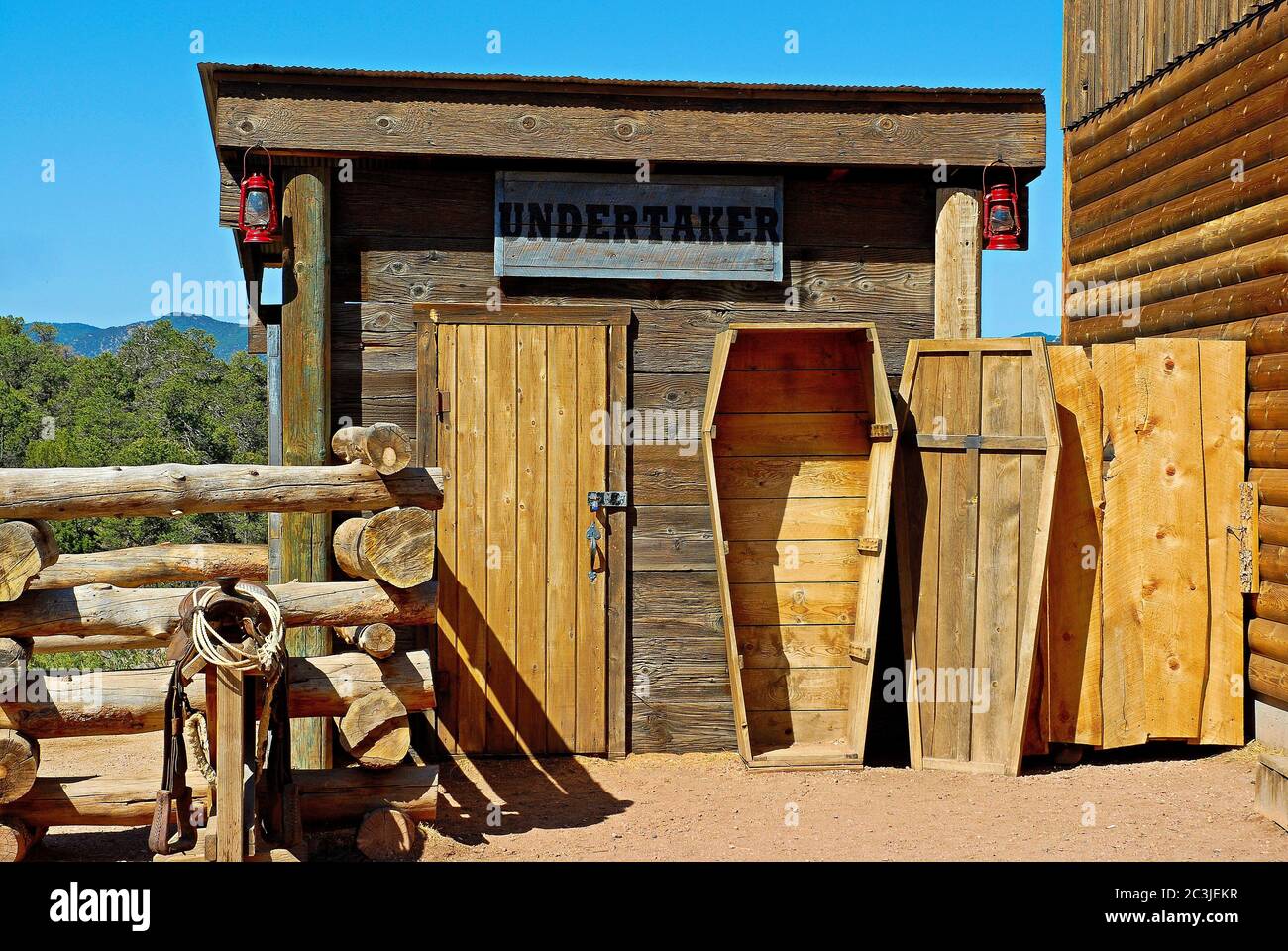 Open wooden coffin in front of a carpenter's studio with an Undertaker sign Stock Photo