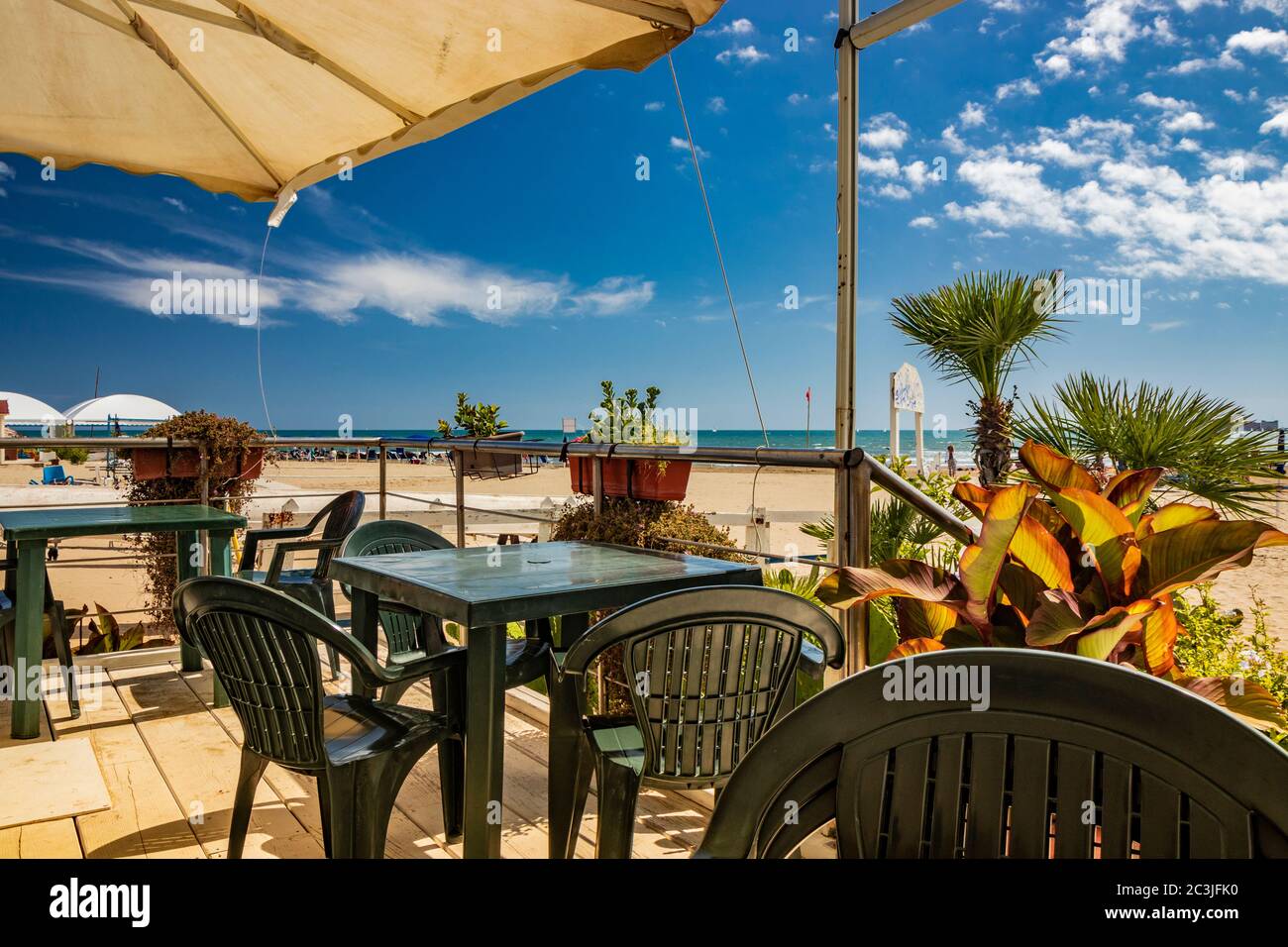 June 14, 2019 - Nettuno, Lazio, Rome, Italy - The empty tables of the bar of a bathhouse and the semi-deserted beach, on a windy day in late summer. T Stock Photo