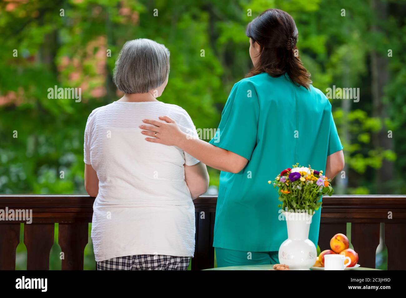 Elderly woman spending time with her assistance in nursing home care center. Stock Photo