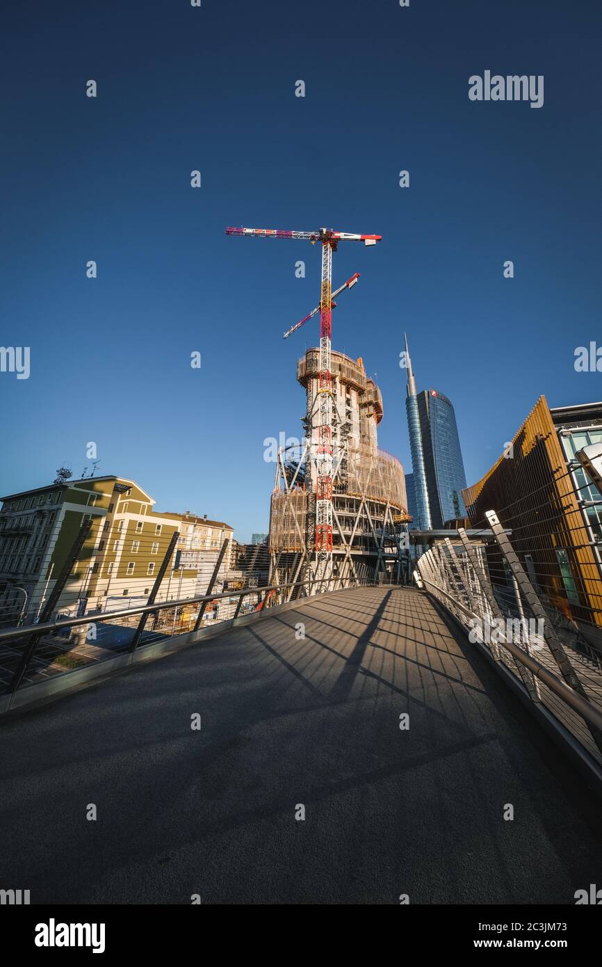 Vertical low angle shot of a building construction with two crane ...