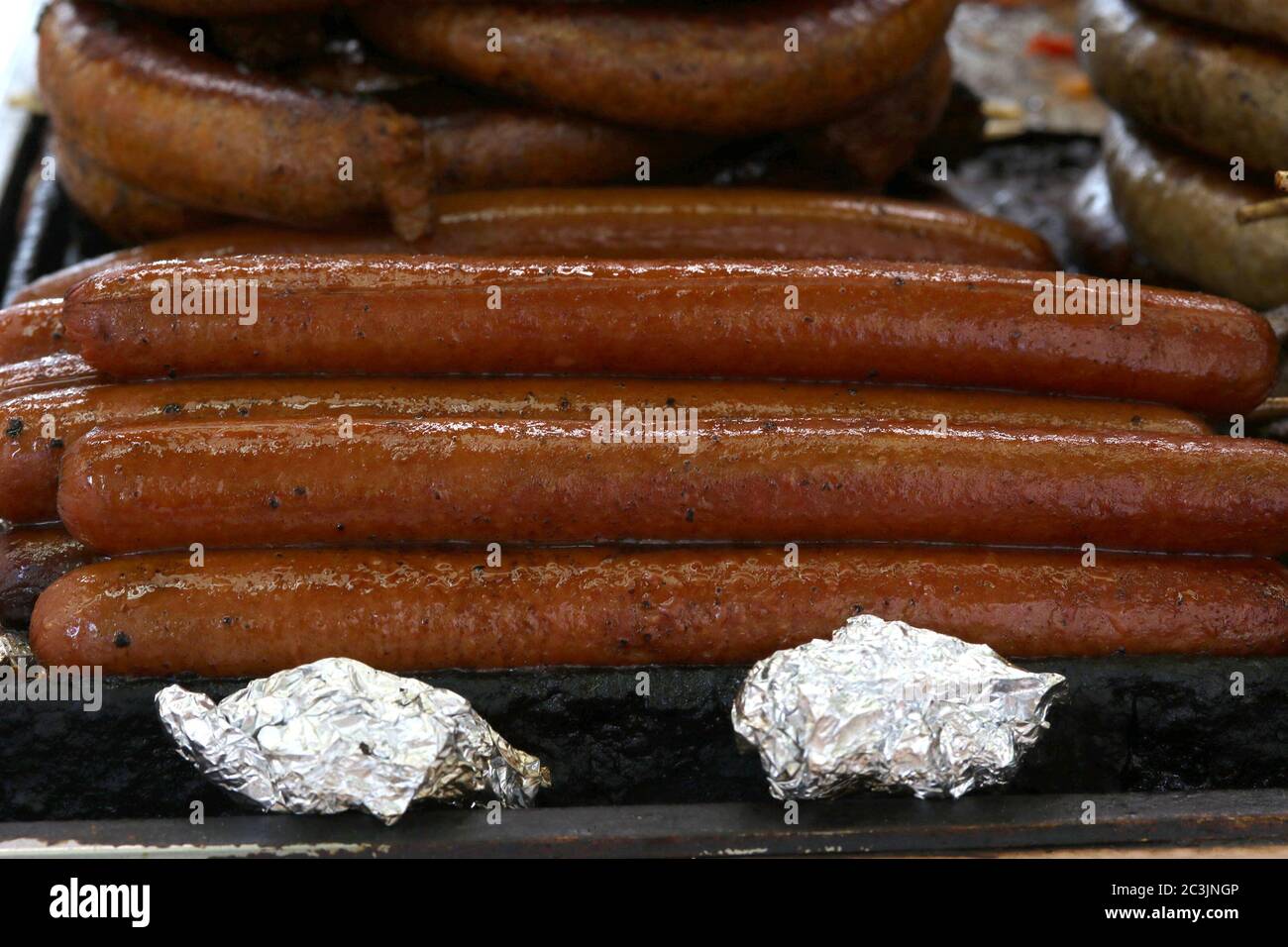 Hot dogs with seasonings on grill Stock Photo