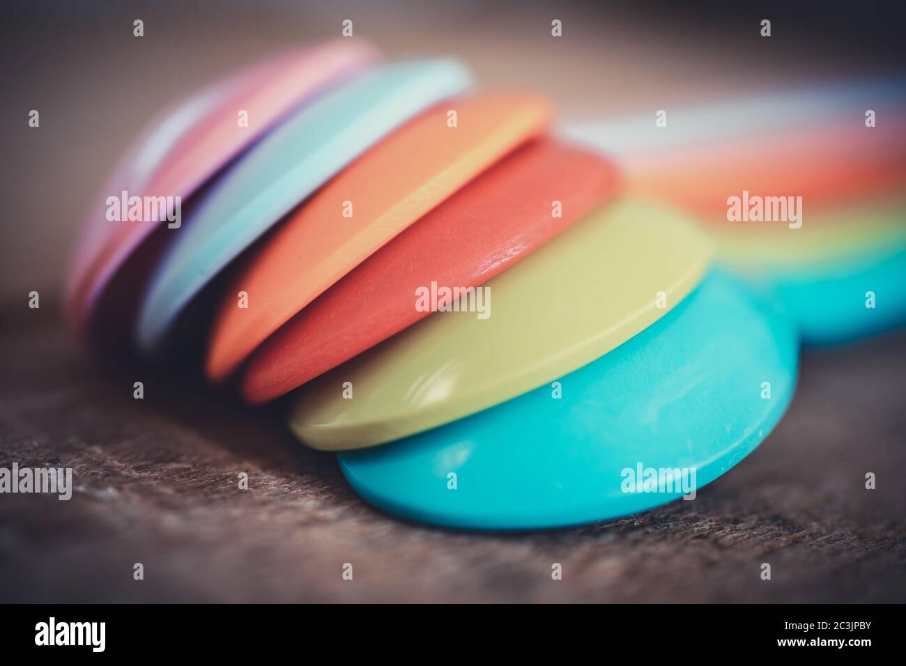 close-up of colorful plastic spoons on each other. teaspoon are laying on wooden table Stock Photo