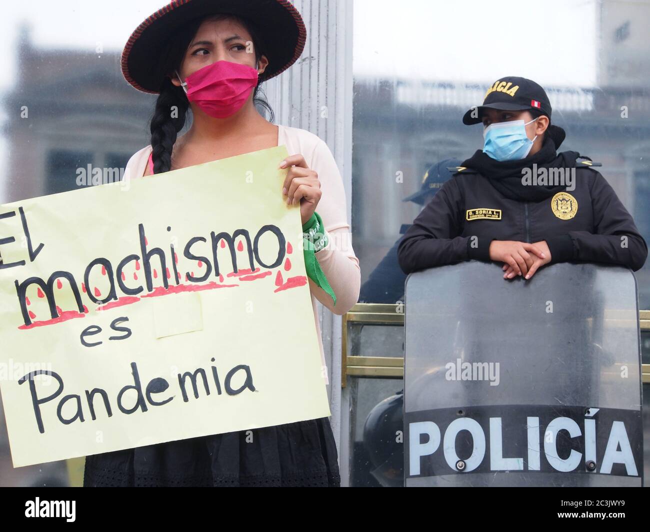 A girl with a banner 'machismo is a pandemic' when feminist demonstrators using masks, due to Covid-19, organizes a sit-in in front of the prosecutor´s office in Lima, in protest against gender violence and femicides Stock Photo