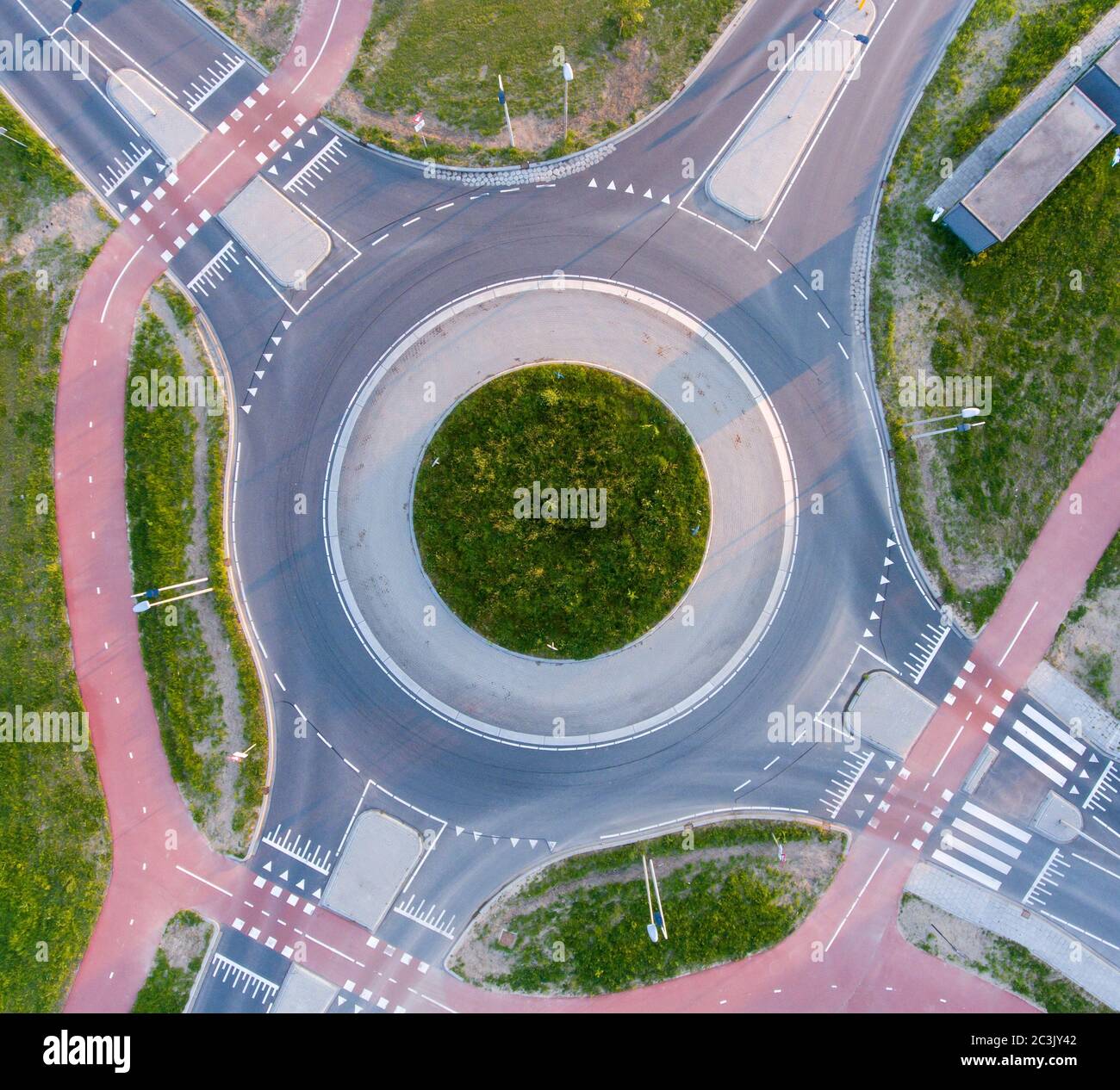 Aerial shot of a roundabout surrounded by greenery under the sunlight ...