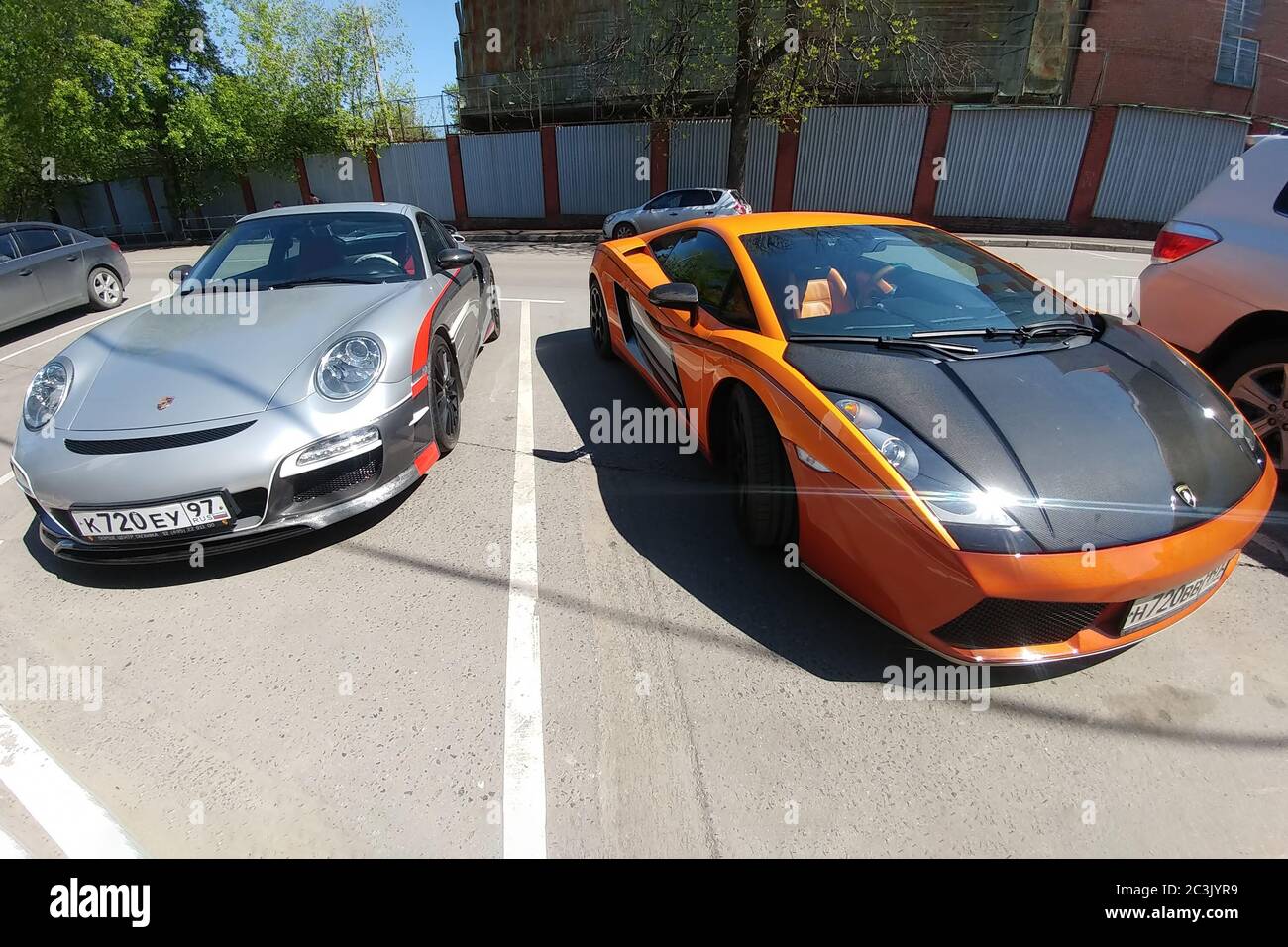 Moscow, Russia - April 14, 2019: Porsche 911 with aerography and Mansory tuning near bright orange Lamborghini Gallardo with carbon hood and other parts parked on the street Stock Photo