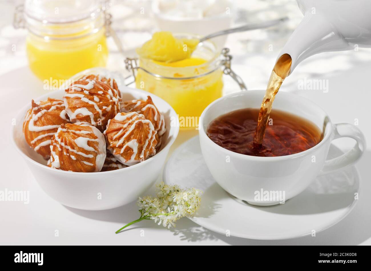 A Cup of hot tea with cookies and honey on a white background, the filling process . Electoral focus Stock Photo